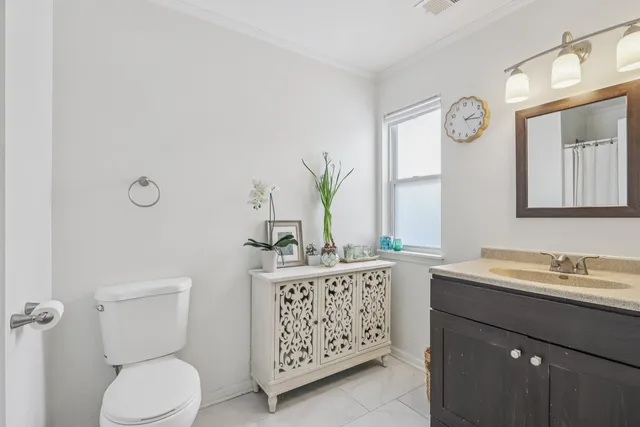a bathroom with a granite countertop sink a toilet and a mirror