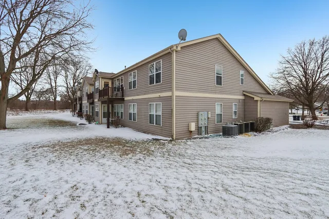 a front view of a house with a yard covered in snow
