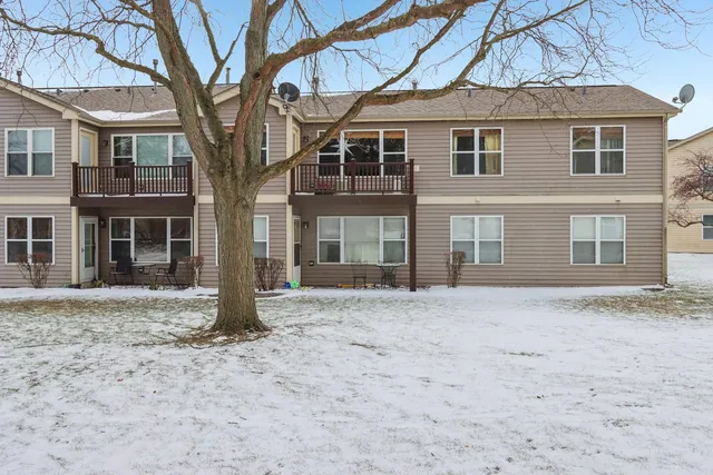 a front view of a house with a yard covered in snow