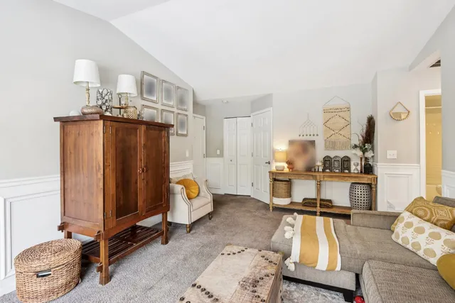 a living room with furniture a flat screen tv and a table