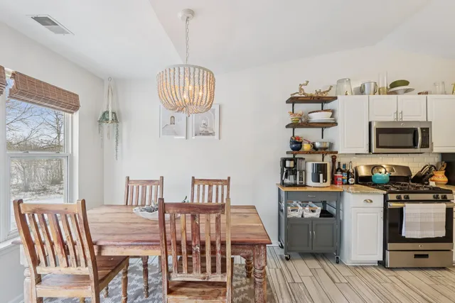 a view of a dining room with furniture wooden floor and a chandelier