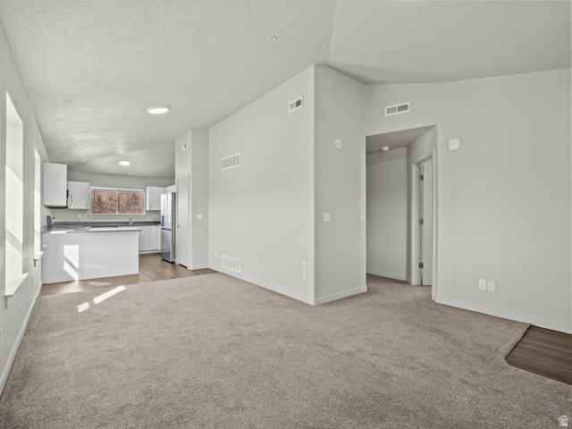 64 West 600 South, Unit C301 Springville, UT 84663 - Photo 3 of 40 Unfurnished living room featuring light colored carpet and baseboards