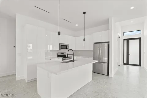 a kitchen with stainless steel appliances a refrigerator sink and microwave