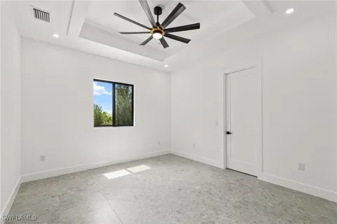 an empty room with a ceiling fan and a window