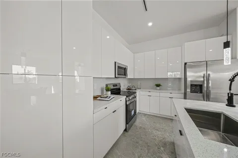 a kitchen with a sink a refrigerator and cabinets