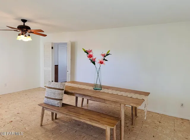 a dining room with furniture and a potted plant