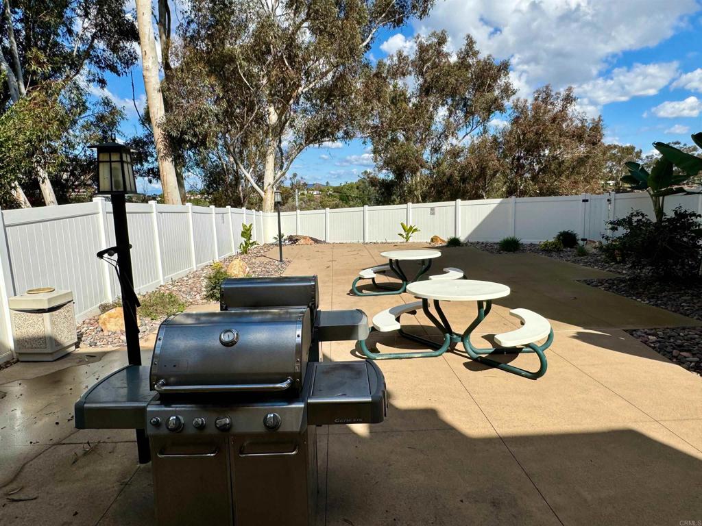 3030 Suncrest Drive, Unit 702 San Diego, CA 92108 - Photo 16 of 17 a backyard of a house with table and chairs