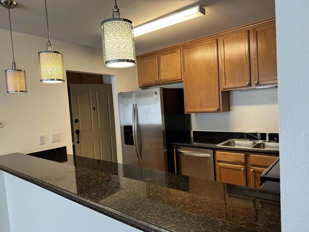 3030 Suncrest Drive, Unit 702 San Diego, CA 92108 - Photo 5 of 17 a kitchen with stainless steel appliances granite countertop a stove a refrigerator and a granite counter tops