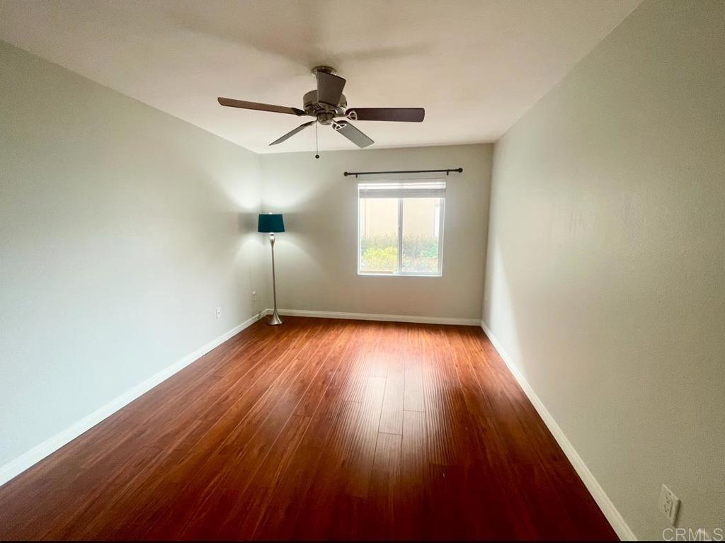 3030 Suncrest Drive, Unit 702 San Diego, CA 92108 - Photo 9 of 17 an empty room with wooden floor fan and windows