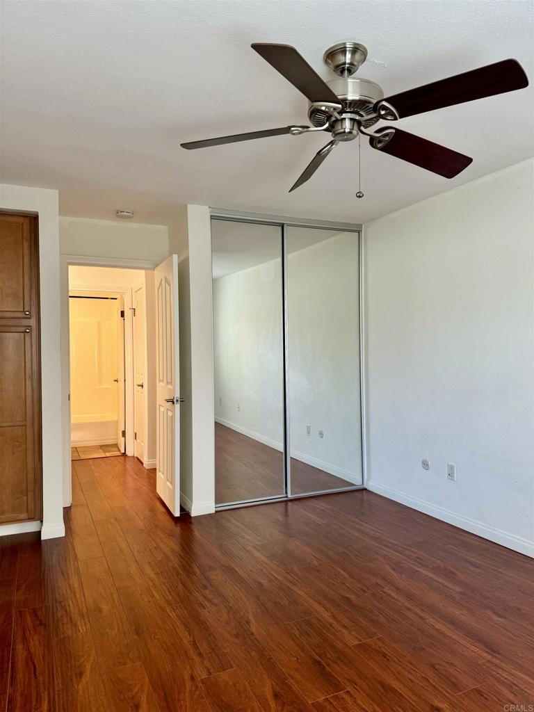 3030 Suncrest Drive, Unit 702 San Diego, CA 92108 - Photo 10 of 17 an empty room with wooden floor fan and windows