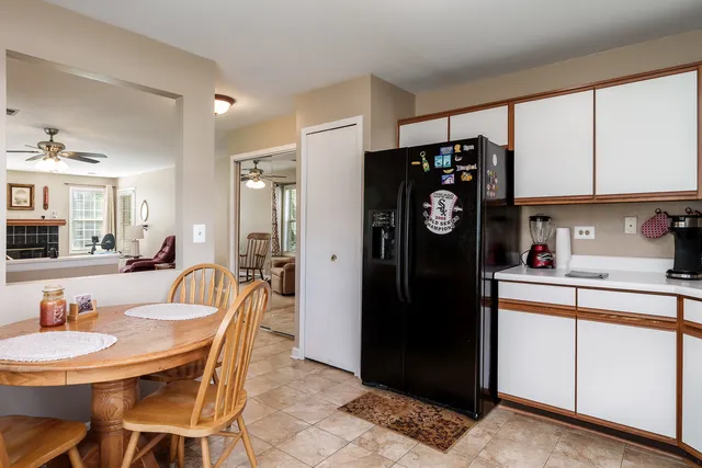 a kitchen with stainless steel appliances granite countertop a refrigerator a sink a dining table and chairs