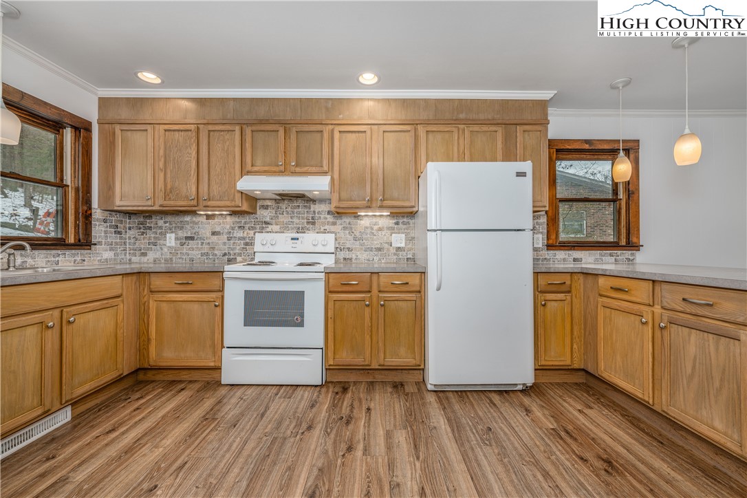 217 Highland Avenue Boone, NC 28607 - Photo 11 of 33 a kitchen with kitchen island granite countertop wooden cabinets and white appliances