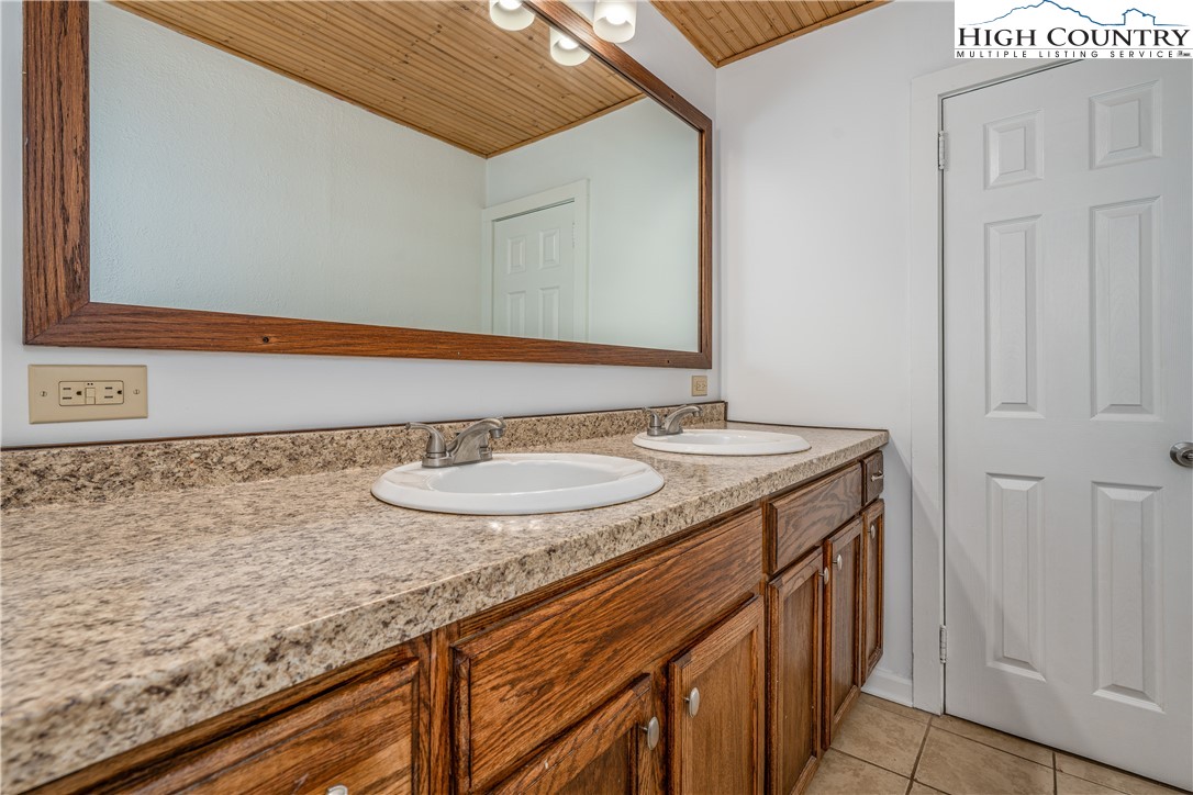 217 Highland Avenue Boone, NC 28607 - Photo 19 of 33 a bathroom with a granite countertop sink and a mirror