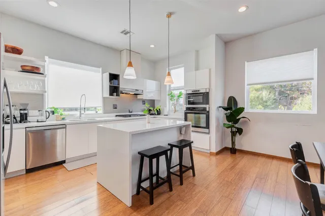 a large kitchen with white cabinets and stainless steel appliances