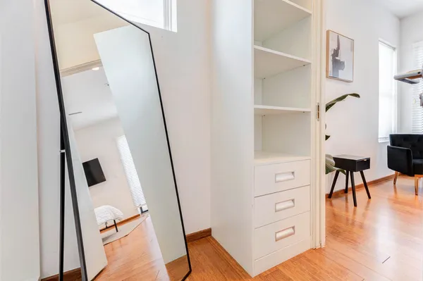 a bedroom with a bed and a potted plant on the dresser