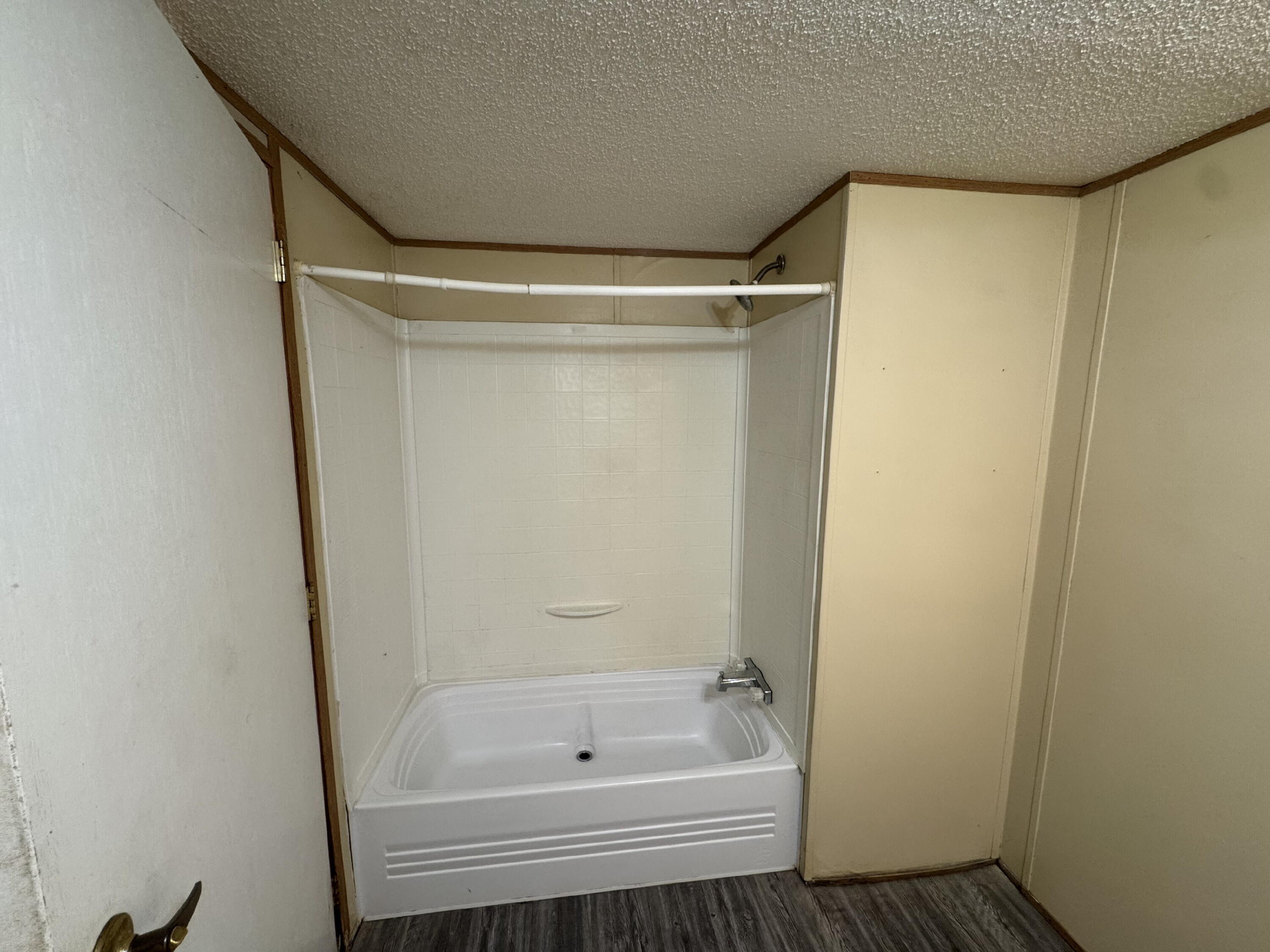 7008 North C R 1500, Unit 20 Shallowater, TX 79363 - Photo 6 of 8 a bathroom with a bathtub and a shower