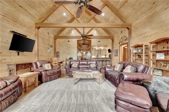 a living room with furniture a flat screen tv and a floor to ceiling window