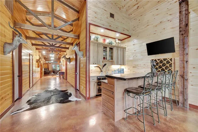 a kitchen with stainless steel appliances granite countertop a stove top oven a sink a dining table and chairs