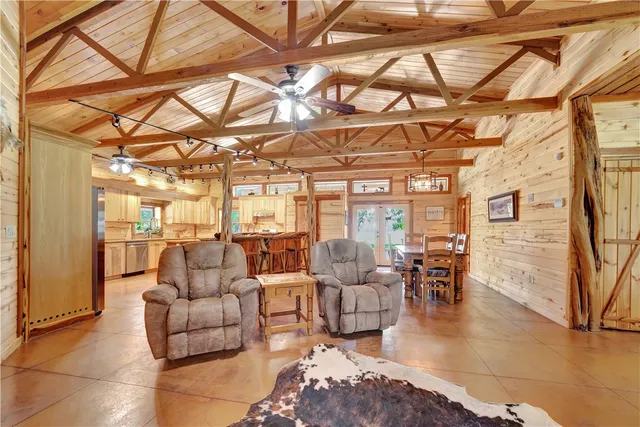 a view of a dining room with furniture a chandelier and kitchen view