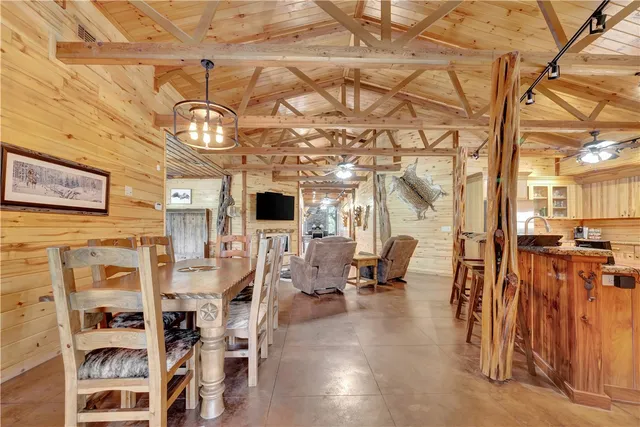 a dining table with chairs and kitchen view