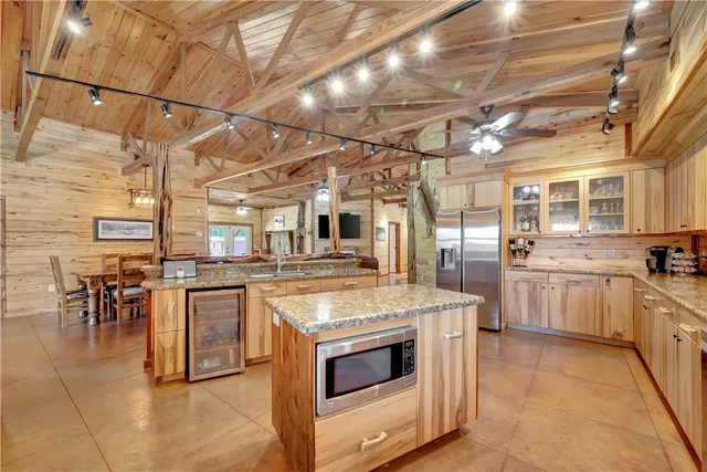 a large kitchen with stainless steel appliances granite countertop a large stove a sink and a refrigerator