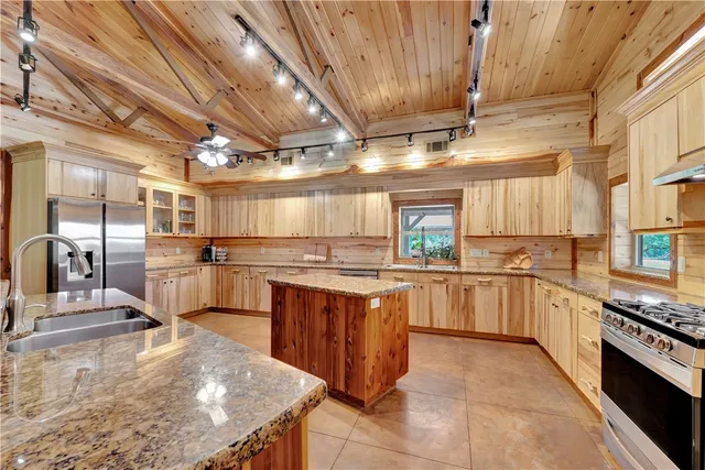 a kitchen with stainless steel appliances granite countertop a sink and cabinets