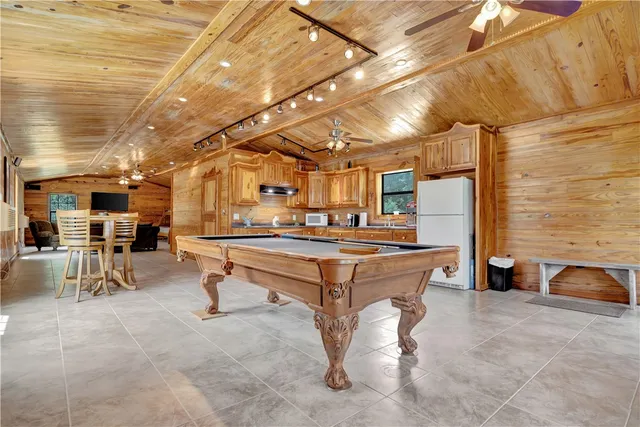 a dining room with furniture a chandelier and wooden floor