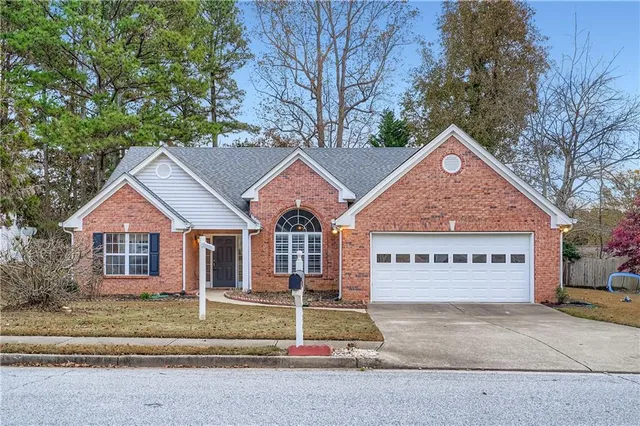 a view of a house with a yard and large tree