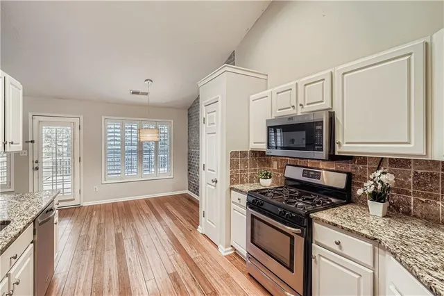 a kitchen with stainless steel appliances granite countertop a stove and a microwave