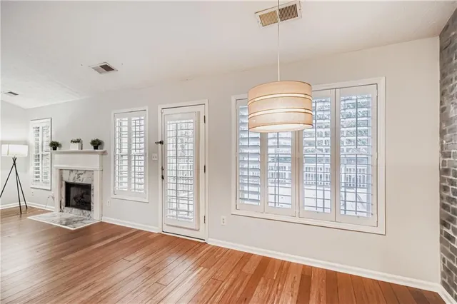 an empty room with fireplace wooden floor and windows