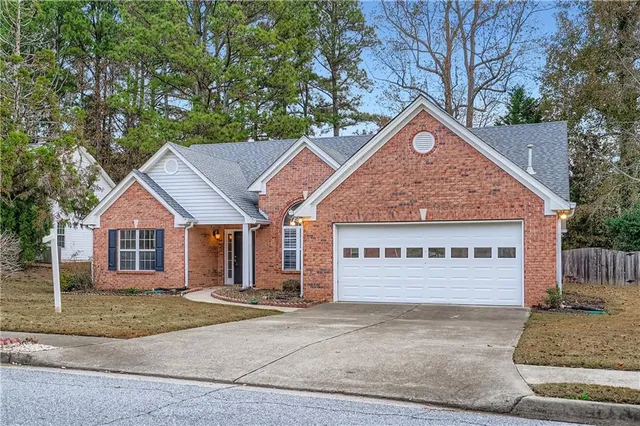 a view of a white house with large windows and a tree