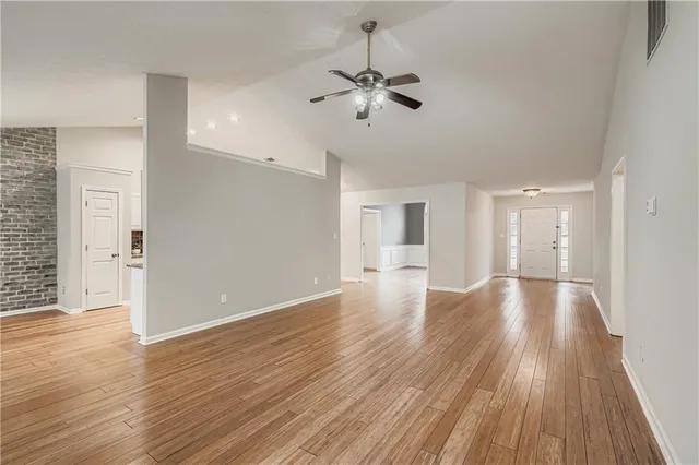 a view of a room with wooden floor and ceiling fan