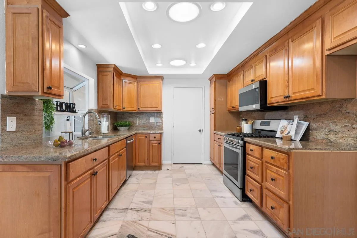 719 Mahogany Drive El Cajon, CA 92019 - Photo 12 of 30 a large kitchen with stainless steel appliances granite countertop a stove a sink and a refrigerator