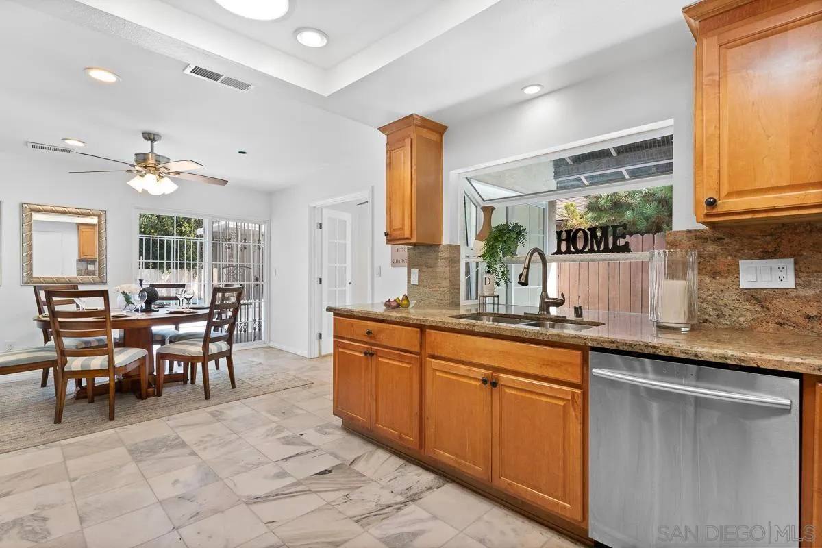 719 Mahogany Drive El Cajon, CA 92019 - Photo 13 of 30 a kitchen with stainless steel appliances granite countertop table chairs sink and cabinets