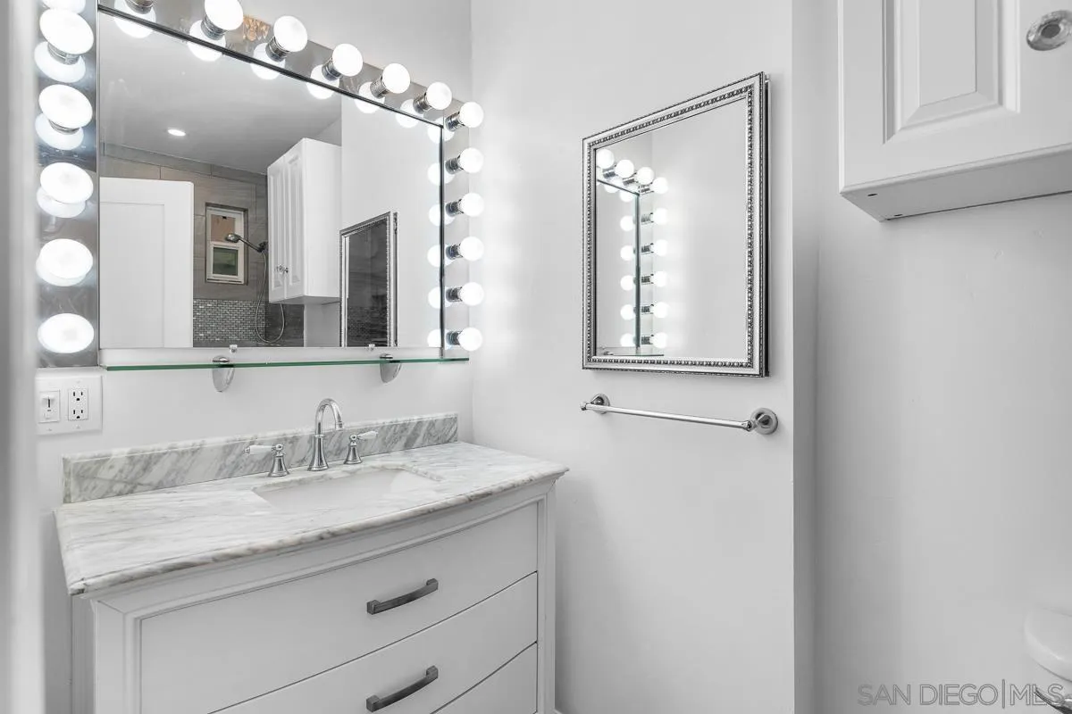 719 Mahogany Drive El Cajon, CA 92019 - Photo 17 of 30 a bathroom with a granite countertop sink mirror and vanity