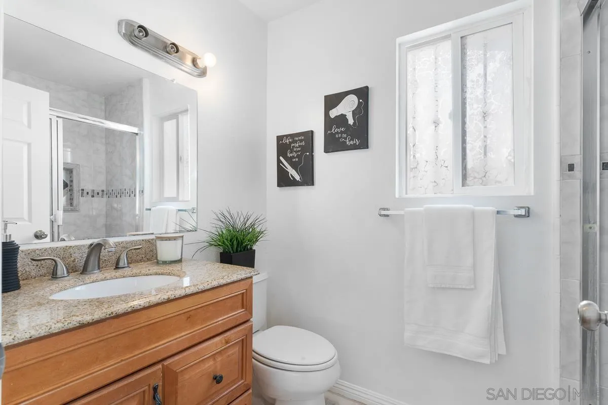 719 Mahogany Drive El Cajon, CA 92019 - Photo 26 of 30 a bathroom with a granite countertop sink mirror vanity and toilet