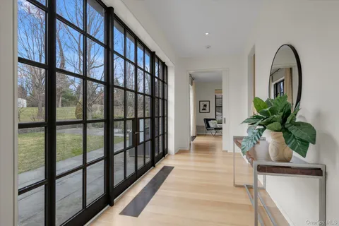 a hallway with wooden floor and a potted plant