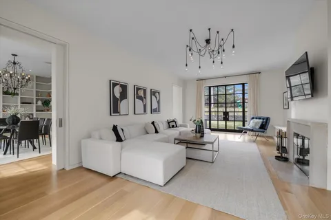 a living room with furniture a chandelier and a flat screen tv