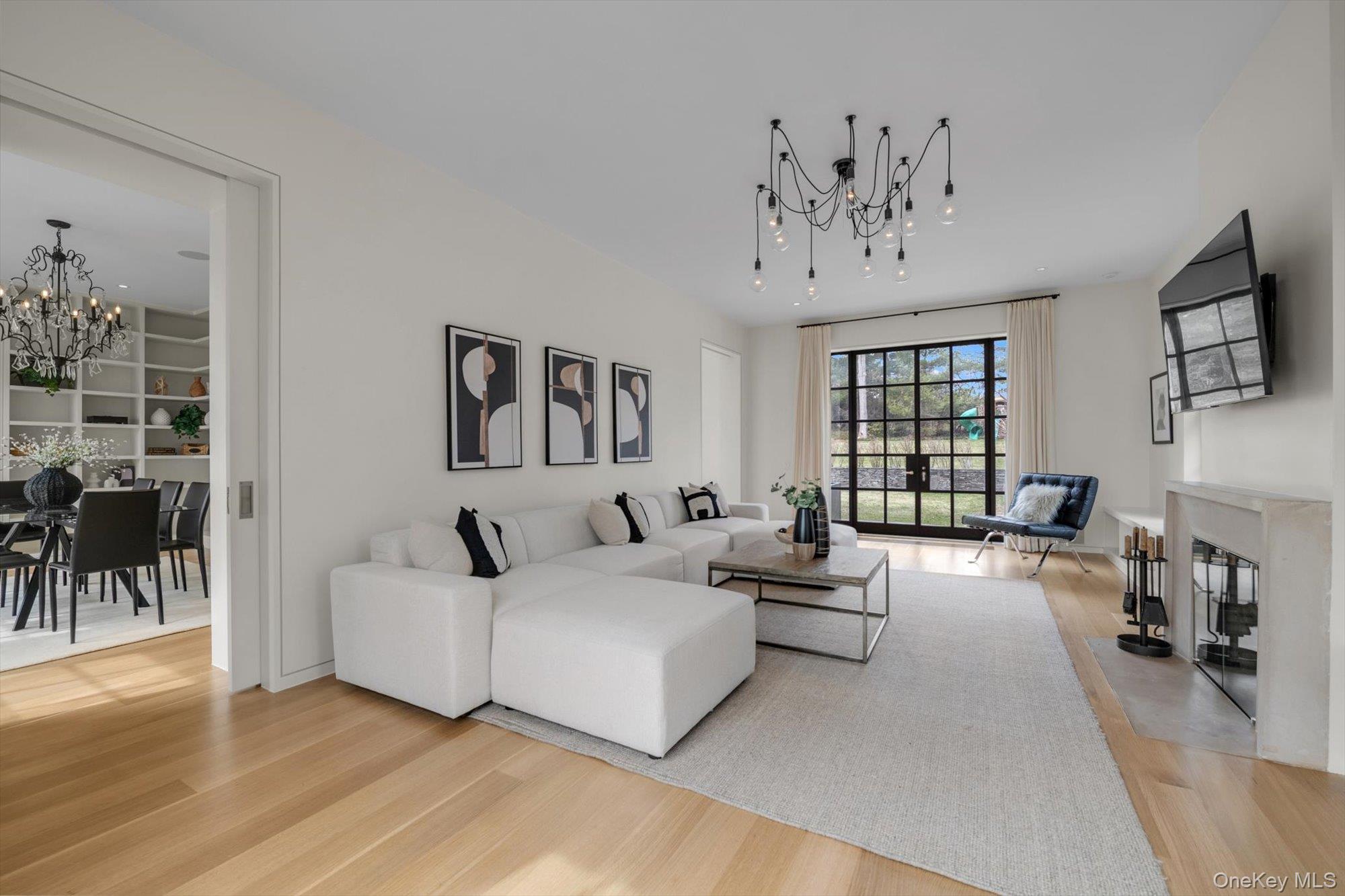 217 Sands Point Road Sands Point, NY 11050 - Photo 14 of 39 a living room with furniture a chandelier and a flat screen tv