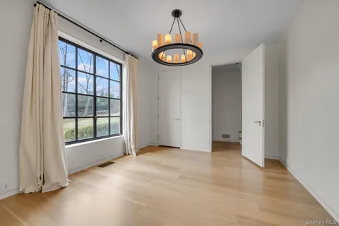 an empty room with a window and a chandelier