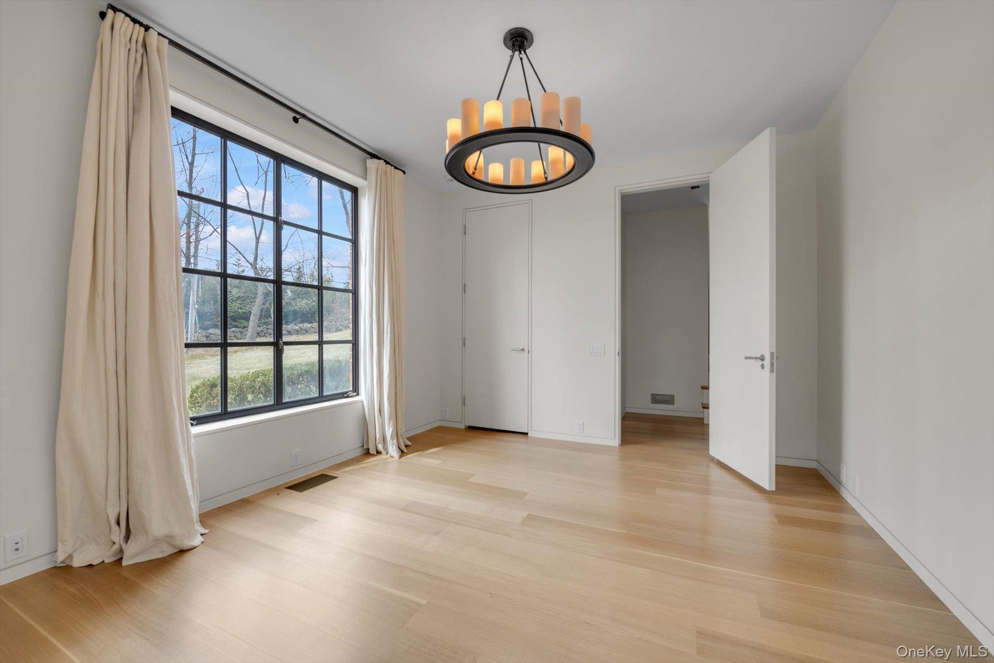 217 Sands Point Road Sands Point, NY 11050 - Photo 18 of 39 an empty room with a window and a chandelier