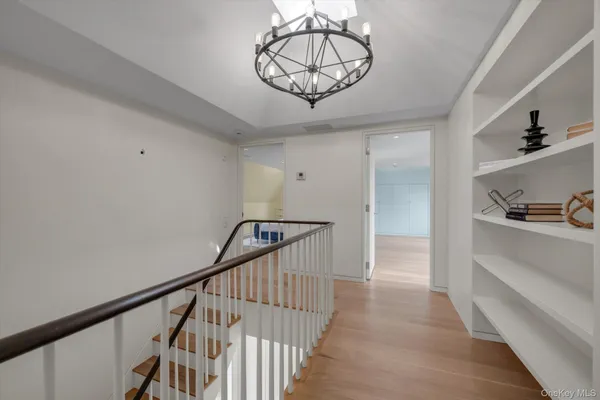 a view of a hallway to a livingroom with wooden floor and entryway