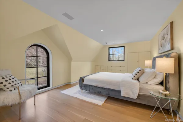 a bedroom with a large bed and wooden floor