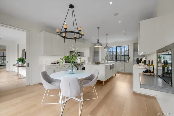 a view of a dining room and livingroom with furniture wooden floor a chandelier