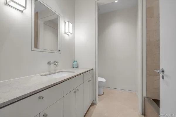 a bathroom with a sink a toilet and a mirror