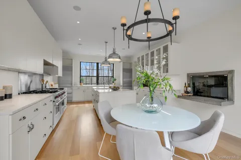 a kitchen with stainless steel appliances a dining table a sink and cabinets