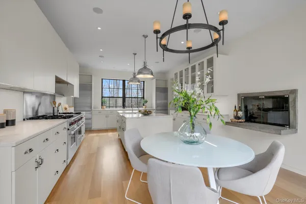 a kitchen with stainless steel appliances a dining table a sink and cabinets