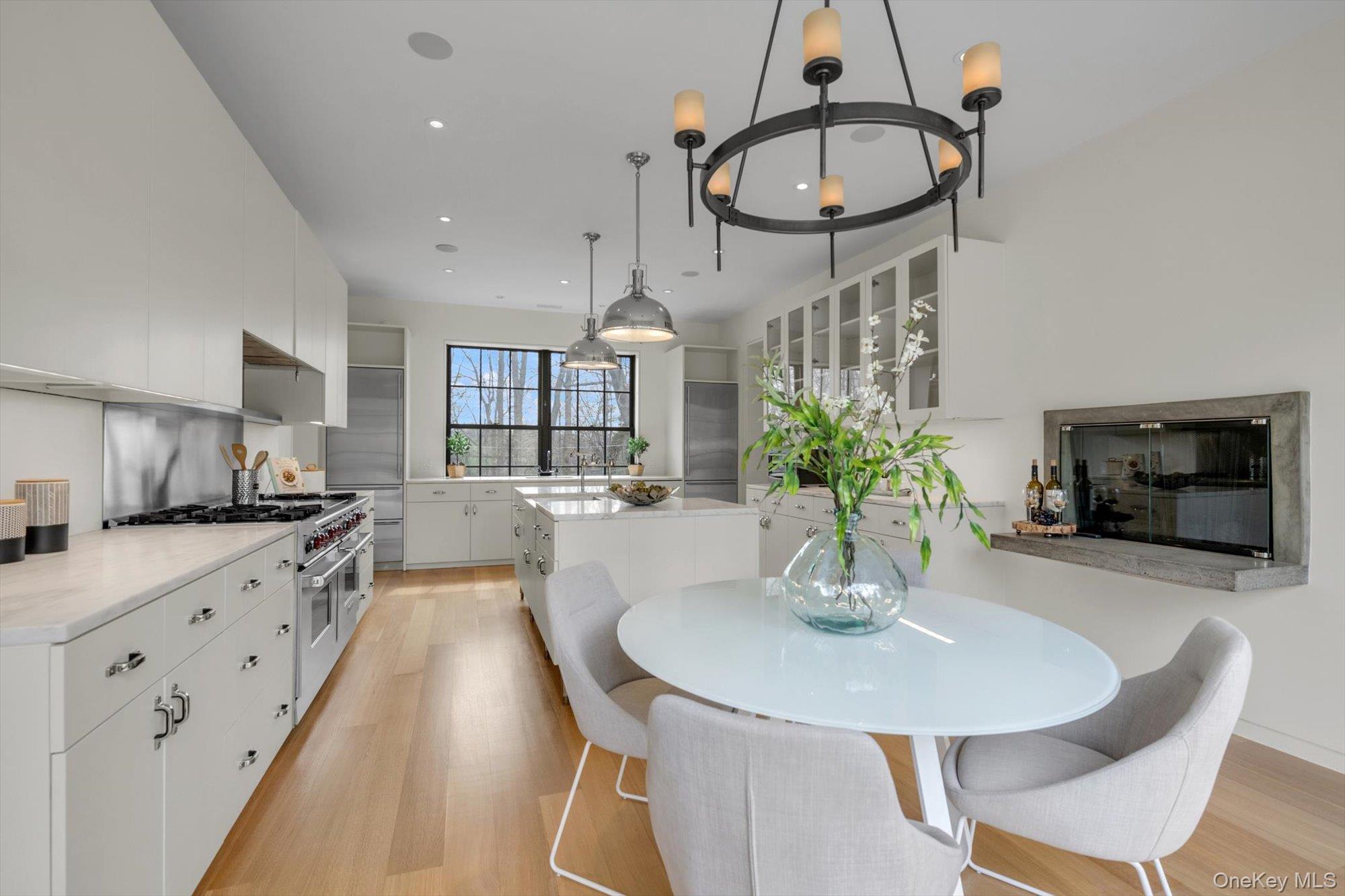 217 Sands Point Road Sands Point, NY 11050 - Photo 5 of 39 a kitchen with stainless steel appliances a dining table a sink and cabinets