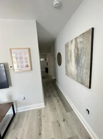 a view of a hallway with wooden floor and a workspace