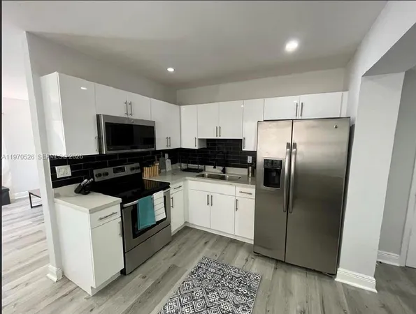 a kitchen with granite countertop a refrigerator stove and microwave